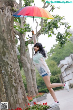 A woman standing on a bridge holding an umbrella.