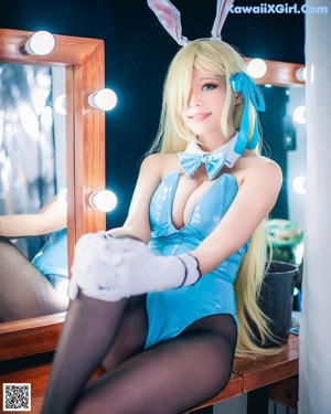 A woman in a bunny costume posing in front of a washing machine.