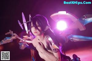 A woman in a futuristic outfit sitting on the ground.