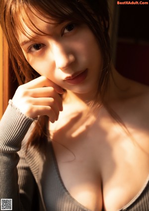 A woman in a bathtub with her hands on her breasts.