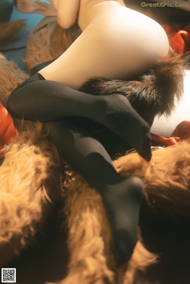 A woman laying on top of a teddy bear.