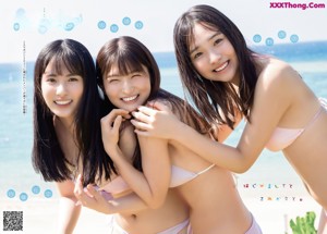 A group of three women in bikinis standing next to each other.
