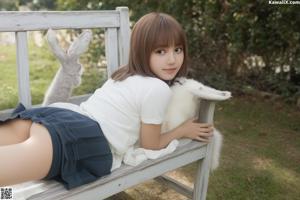 A woman in a white dress sitting on a white couch.