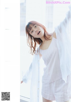 A woman in a white shirt is posing for a picture.
